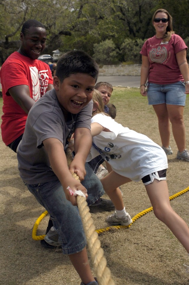 Killeen, Texas native, Joseph Rodriquez, whose favorite part of camp was the 'water-slide,' competes in a tug of war match against other campers during the Armed Services YMCA summer camp.  Held at the Peaceable Kingdom Retreat for Children in...
