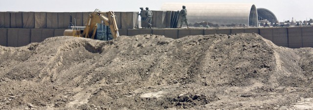 Army construction engineers build a  barrier wall at Forward Operating Base Hunter in southeastern Iraq Aug. 28. The Soldiers fill the barriers with dirt to provide a higher level of security. The squadron recently left Convoy Support Center Scania a...