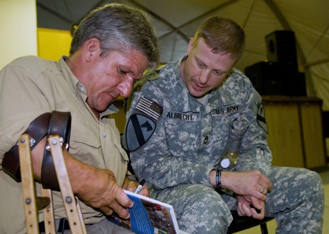 Matt Roloff, star of The Learning Channel's show "Little People, Big World" signs a book for Sgt. First Class Kevin Albrecht from the Headquarters and Headquarters Company, 4th Special Troops Battalion, 4th Brigade Combat, 1st Cavalry Division at the...