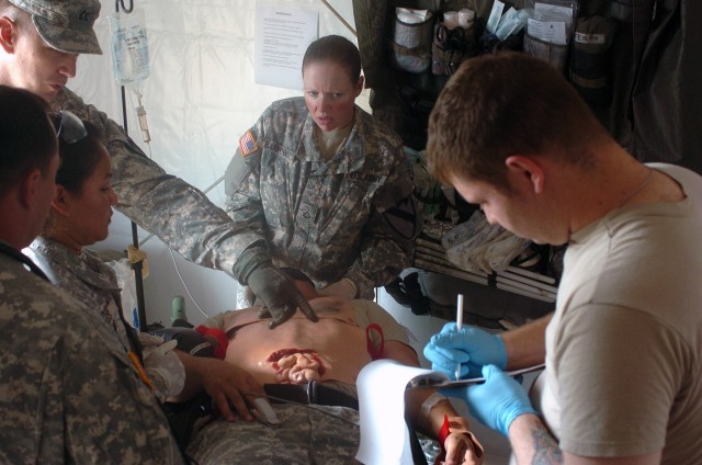 The "Ironhorse" Brigade Combat Team's surgeon Capt. Kenneth Dekay of Austin, Texas, points to simulated wounds on Spc. William St. Andry during a mass casualty exercise at Fort Hood, Texas, Sept. 8. St. Andry was evaluated then later prepped for evac...
