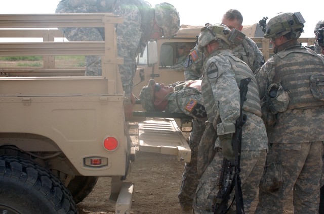 Spc. William St. Andry assigned to the 2nd Battalion, 5th Cavalry Regiment's  Headquarters and Headquarters Company, is loaded into a vehicle to be transported to a mock aid-station during the 1st "Ironhorse" Brigade Combat Team's two-week, pre-deplo...