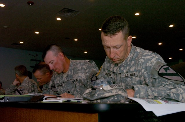 Lt. Cols. Scott Jackson (R-L), David Lesperance, Thomas Shoffner, and Terry Cook, look over documents while attending the Joint Readiness Training Center's (JRTC) operations and intelligence brief at Fort Polk, La. Sept. 13. The briefing kicked off t...