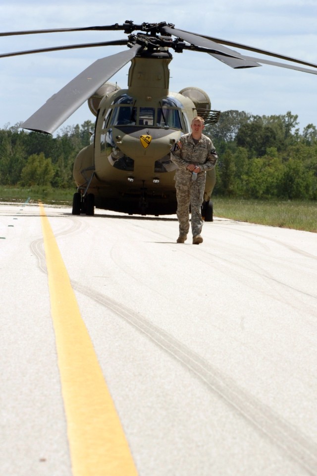 Spc. Trinity Cline, a CH-47 Chinook helicopter flight engineer for 2nd Battalion, 227th Aviation Regiment, 1st Air Cavalry Brigade, 1st Cavalry Division, walks away from his aircraft as he waits for a re-supply mission at an air field in Lufkin,...