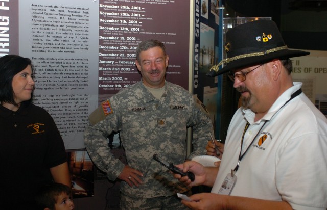 While calling the winner of a new Stetson via cell phone, Steven Draper, director, 1st Cavalry Division museum, gets some good-natured teasing from Seneca Falls, N.Y. native Amber Hills and Applegate, Mich. native Maj. James Womack, a translator...