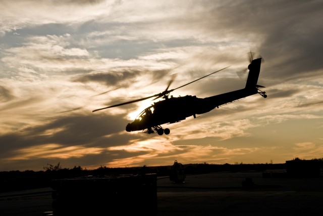 As the sun begins to set, an AH-64D Apache attack helicopter pilots from 1st "Attack" Battalion, 227th Aviation Regiment, 1st Air Cavalry Brigade, 1st Cavalry Division, takes off from a forward arming and refueling point to take part in Iron Horse Ra...