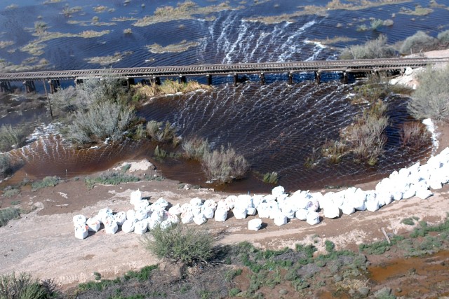 A levee near the Rio Grande River in Presidio, Texas, threatens to overflow into the city if the water level rises much more, but the CH-47 Chinook helicopter pilots and crewmembers from Company B "Black Cats," 2nd Battalion, 227th Aviation Regiment,...