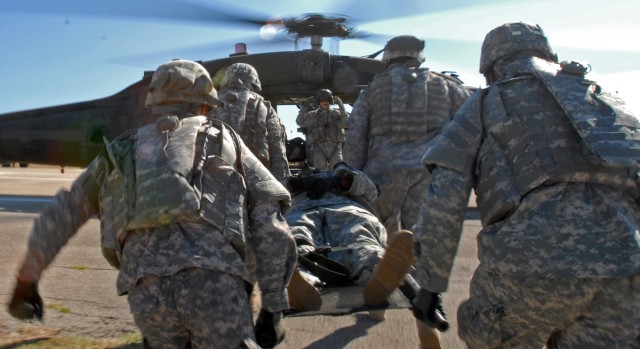 Soldiers from the 154th Transportation Company, 180th Transportation Battalion, 15th Sustainment Brigade, 13th Sustainment Command (Expeditionary), carry a simulated casualty to a medical evacuation helicopter during medevac training Oct. 2. The...