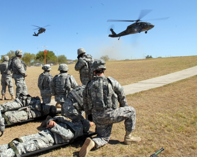 Soldiers from the 154th Transportation Company, 180th Transportation Battalion, 15th Sustainment Brigade, 13th Sustainment Command (Expeditionary), wait to load simulated patients on to the landing medical evacuation helicopters during medevac...