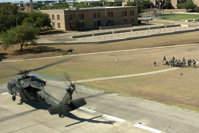 A medical evacuation helicopter from Company C, 2nd Battalion, 227th Aviation Regiment, lands on a Fort Hood helipad as Soldiers from the 154th Transportation Company, 180th Transportation Battalion, 15th Sustainment Brigade, 13th Sustainment...