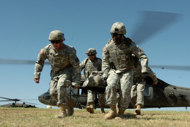 Soldiers from the 154th Transportation Company, 180th Transportation Battalion, 15th Sustainment Brigade, 13th Sustainment Command (Expeditionary), carry a fellow Soldier away from a medical evacuation helicopter during medevac training Oct. 2 at...