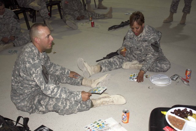 Sergeant First Class Philip Walls, and Staff Sgt. Courtney James, members of Headquarters and Headquarters Company, 4th Special Troops Battalion, 4th BCT, 1st Cav. Div., play Loteria or Mexican Bingo during the Hispanic Heritage Month celebration at ...