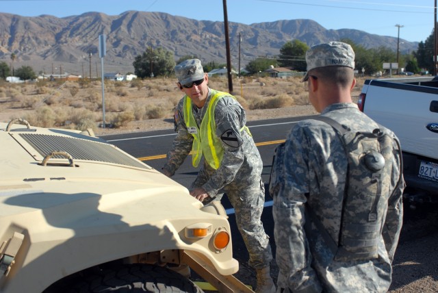 1st Brigade Combat Team, 1st Cavalry Division Safety and Occupational Health Specialist Stephen W. Bell (left) of Nolanville, Texas gives a Soldier instruction while he prepares to tow a broken-down humvee back to its original staging area. The...
