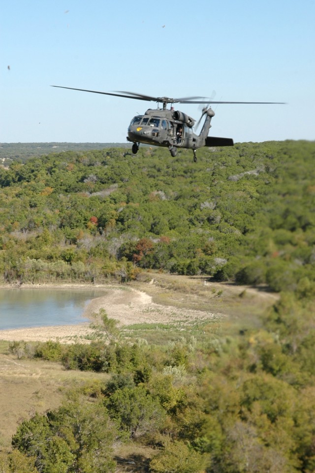 A UH-60 Black Hawk helicopter from the 3rd "Spearhead" Battalion, 227th Aviation Regiment, 1st Air Cavalry Brigade, 1st Cavalry Division, flies over a range at Fort Hood, Texas, during a maneuvers flight Oct. 8. "Spearhead" assault battalion...