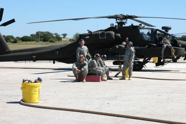 A group of armament and fueling specialists from the 4th "Guns" Battalion, 227th Aviation Regiment, 1st Air Cavalry Brigade, 1st Cavalry Division, hang out and wait for another aircraft to land at a Forward Arming and Refueling Point while some...