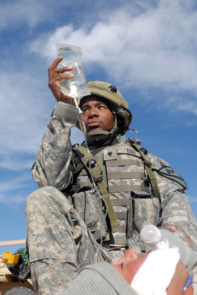 Atlanta, Ga. Native, Spc. Edward Cody, armor, Headquarters and Headquarters Battery, 1st Battalion, 82nd Field Artillery Regiment, 1st Brigade Combat Team, 1st Cavalry Division, holds an I.V. and manually pumps oxygen into the lungs of a simulated...