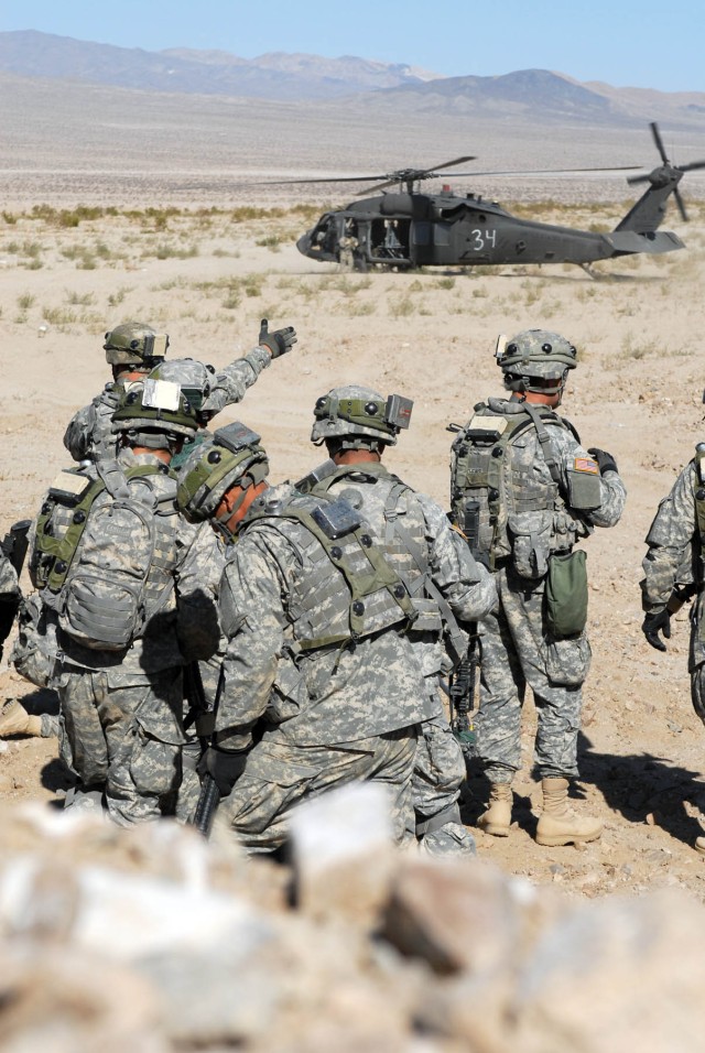 Members of Delta Company, 2nd "Lancers" Battalion, 5th Cavalry Regiment, 1st Brigade Combat Team, 1st Cavalry Division, prepare to evacuate by way of a UH-60 Blackhawk after conducting cordon and search operations inside the training "city" of...