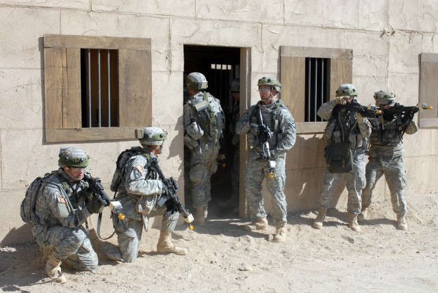 Soldiers from Delta Company 2nd "Lancers" Battalion, 5th Cavalry Regiment, 1st Brigade Combat Team, 1st Cavalry Division pull security at the entrance of the building they used to secure their high value "individual" Oct. 13 at the National...
