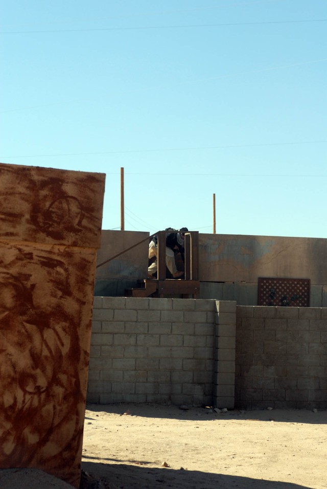 An "insurgent" ,held up within the simulated "city" of Medina Jabal, runs for cover on a rooftop as elements of Delta Company, 2nd "Lancers" Battalion, 5th Cavalry Regiment, 1st Brigade Combat Team, 1st Cavalry Division enter the city Oct. 13. ...