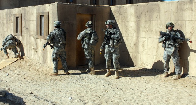 White Platoon Soldiers from 2nd "Lancers" Battalion 5th Cavalry Regiment, 1st Brigade Combat Team, 1st Cavalry Division, stack on a wall just outside the streets of the training site, Medina Jabal, at the National Training Center Oct. 13. These...