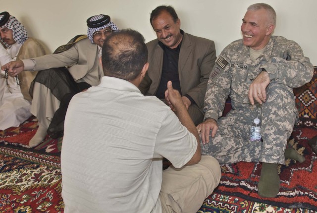Col. Philip Battaglia, the commander of the 4th Brigade Combat Team, 1st Cavalry Division, speaks with a business leader from Nasiriyah with the help of his interpreter near the Ziggurat Oct. 23. The Catholic archbishop for Iraq and Jordan visited...