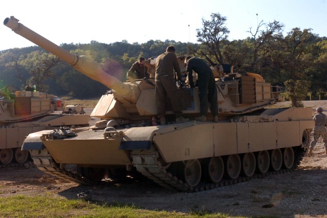 Soldiers from the 1st Battalion, 5th Cavalry Regiment, 2nd Brigade Combat Team, 1st Cavalry Division, perform minor repairs before their tank goes on to the range on Oct. 22 at Sugarloaf Multi-Use Range on Fort Hood. The Soldiers are training on...