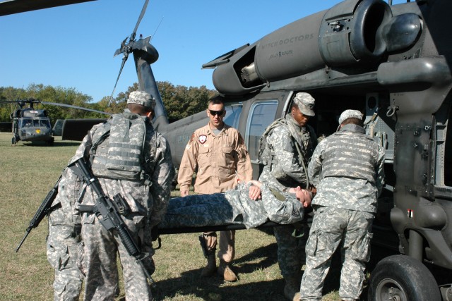 Soldiers from Company B, 303rd Military Intelligence Battalion, load up a fellow Soldier into a UH-60 medical evacuation Black Hawk helicopter under the supervision of 1st Sgt. David Falk, the senior noncommissioned officer for Co. C, 2nd Battalion, ...