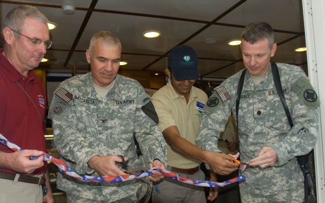Jerry Myers, the COB Adder PX general manager; Col. Philip Battaglia, the Long Knife Brigade commander; Kinl Clinton, the Green Beans Coffee manager; and Lt. Col. James Treece, COB Adder garrison commander; cut the ribbon during the grand opening...