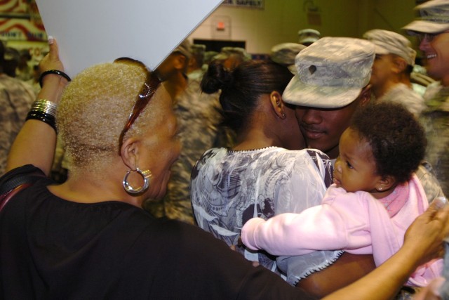 Ethel Gillard prepares to hug her son Spc. Joshua Gillard, a truck driver with the 418th Transportation Company, 180th Transportation Battalion, 15th Sustainment Brigade, as he hugs his wife C'alace and daughter Jordan Nov. 3 at the Kieschnick Physic...