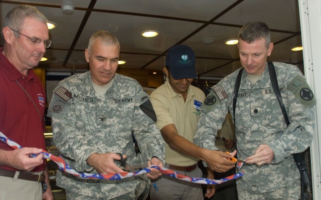 Jerry Myers, the COB Adder PX general manager; Col. Philip Battaglia, the Long Knife Brigade commander; Kinl Clinton, the Green Beans Coffee manager; and Lt. Col. James Treece, COB Adder garrison commander; cut the ribbon during the grand opening of ...