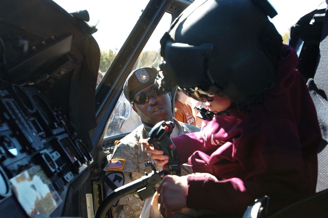 Blaine Grinalds (right), one of the few teen campers at Peaceable Kingdom Retreat for Children, a camp for teens and children with disabilities and chronic illness, checks out the cockpit of a UH-60 Black Hawk helicopter with the help of Spc....