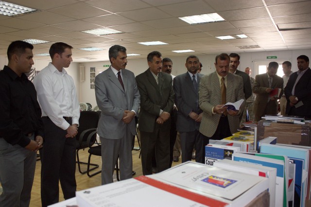 Dhi Qar University officials look over academic textbooks donated by Oregon State University, in partnership with the Michael Scott Mater Foundation Nov. 11 near Nasiriyah.  Josh Mater (2nd from left) worked through the foundation to establish a part...