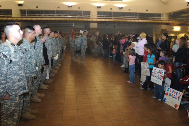 Members of the 377th Transportation Company, a part of the Fort Hood-based 180th Transportation Battalion, 15th Sustainment Brigade, and their families wait to be dismissed during a welcome home ceremony for the Soldiers Nov. 14 at Fort Bliss' Biggs ...