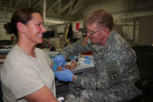 Army Surgeon General draws blood from Soldier during medical reintegration