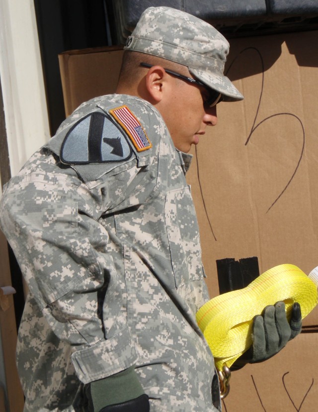 Roswell, N.M. native Spc. Valentine Alvarado, a member of the brigade's personal security detachment from Headquarters and Headquarters Troop, 1st Brigade Combat Team, 1st Cavalry Division begins to ratchet strap the contents of a container in order ...