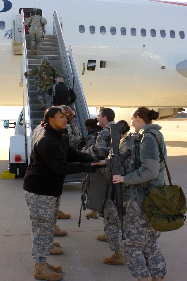 Soldiers from Detachment D, 230th Financial Management Company, say goodbye to members of their chain of command before boarding a plane bound for the Middle East Dec. 21 at Robert Gray Army Airfield. The Soldiers began a year-long deployment in supp...