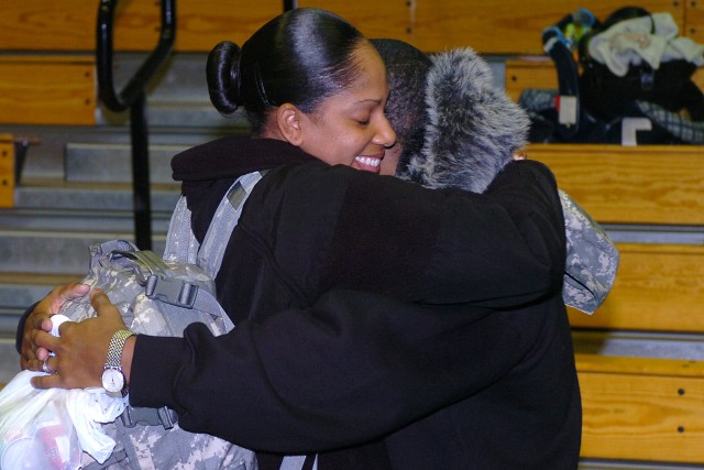 Sgt. Janel Bartley, a finance clerk with Detachment D, 230th Financial Management Company, hugs Devaughn Bartley during a deployment ceremony Dec. 21 at the Kieschnick Physical Fitness Center on Fort Hood. About 30 Soldiers from the 230th deployed to...