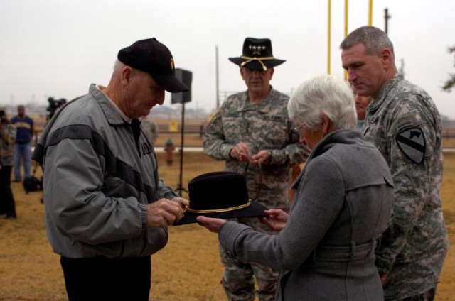 Brigadier General John (Mike) Murray, Deputy Commanding General (Maneuver), 1st Cavalry Division (far right) looks on as his father John Murray (far left) pins the star of Brigadier General on a Stetson held by his mother Janet (third from left) as G...