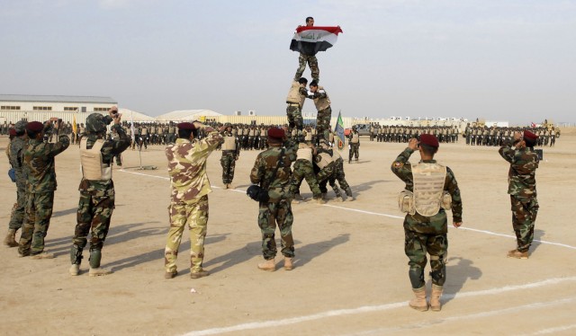 Graduating troops from the 41st Brigade, 10th IA Division assembled a pyramid with an Iraqi Soldier displaying his national flag at the IA graduation at the Besmaya Range Complex Dec. 31. The graduation added approximately 2,100 new troops to the ran...