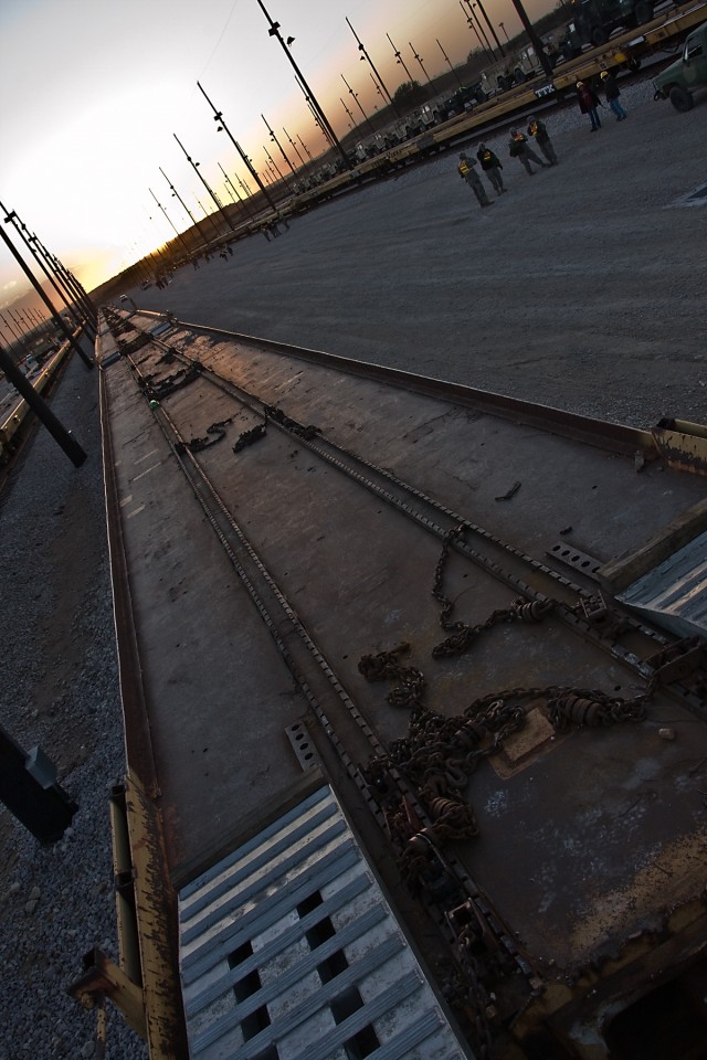 Soldiers of the 1st Air Cavalry Brigade, 1st Cavalry Division, discuss plans to continue loading the remainder of the vehicles on empty rail cars for the following day.  This railhead operation on Fort Hood, Texas, Jan. 6 is an effort to move...