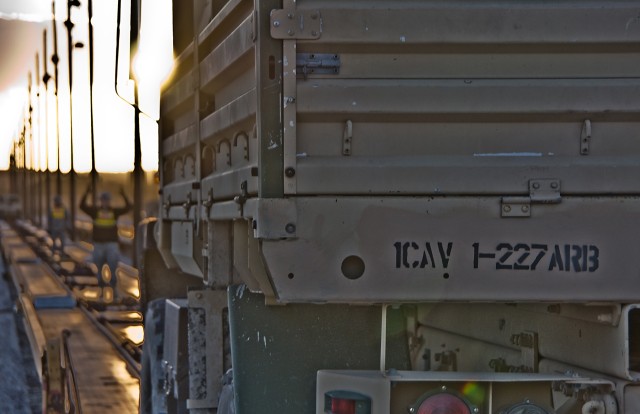 As the sun sets, the Soldiers of the 1st Air Cavalry Brigade, 1st Cavalry Division, continue with railhead operations, Fort Hood, Texas, Jan. 6. Vehicles are being loaded onto rail cars as part of the preparation for a rotation at the National...