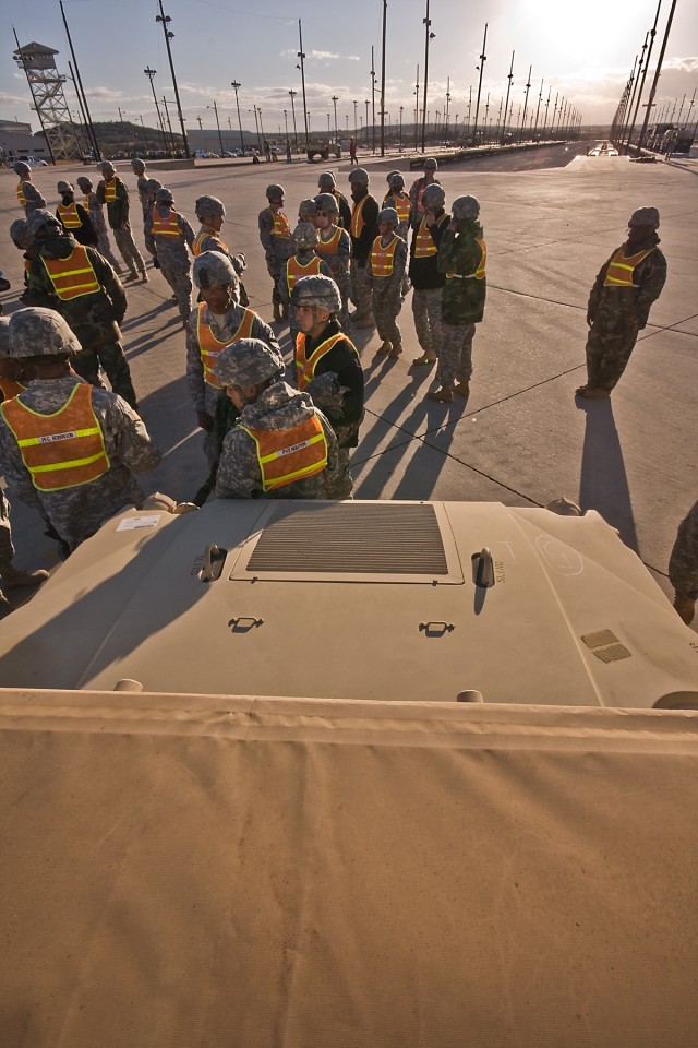 Soldiers from the 1st Air Cavalry Brigade, 1st Cavalry Division, conduct a safety briefing at the head of the vehicle lineup before they load the heavy equipment onto rail cars at the railhead in Fort Hood, Texas, for movement to Fort Irwin,...
