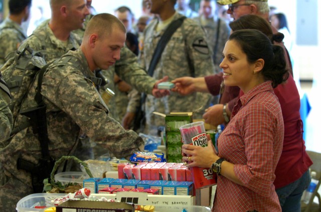 United Services Organization Volunteer, Bulverde,Texas native Lucy Limon (right) offers service with a smile as she provides snacks for Soldiers of the 2nd Brigade Combat Team 1st Cavalry Division Jan. 8 at Fort Hood, Texas before they board their...