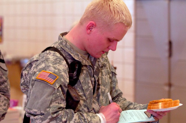 Prior to his flight, Boise, Idaho native Pfc. Michael D. Olsen, a Soldier with Headquarters and Headquarters Company, 1st Battalion, 8th Cavalry Regiment, 1st Cavalry Division, takes time to fill out a prayer request form provided by the members...