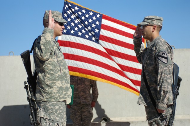 Charleston, W. Va. native Cpt. Phillip Rathbun (left), adjutant for 1st Battalion, 5th Cavalry Regiment, 2nd Brigade Combat Team, 1st Cavalry Division, administers the oath of reenlistment to Houston native Staff Sgt. Michael Robinson, a personnel...