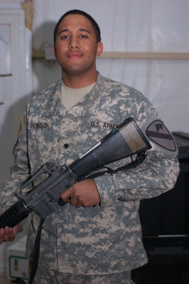 Spc. Jeremiah "Super Rob" Robinson, a systems administrator 4th Squadron, 9th Cavalry Regiment, 2nd Brigade Combat Team, 1st Cavalry Division, shows off his weapon. Robinson is a big music buff. He can play the piano, trumpet and French horn, and he ...