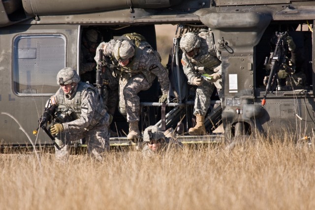 Soldiers from Company F, 3rd Assault Helicopter Battalion, 227th Aviation Regiment, 1st Air Cavalry Brigade, 1st Cavalry Division, hastily dismount a UH-60 Black Hawk helicopter to provide security for a downed aircraft during a training mission...