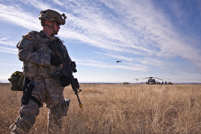 Baltimore native Pfc. John Dixon, a Soldier in Company F, 3rd Assault Helicopter Battalion, 227th Aviation Regiment, 1st Air Cavalry Brigade, 1st Cavalry Division, guards the perimeter as other Blues Platoon Soldiers tend to wounded aircrew...