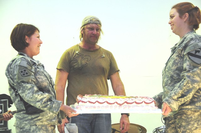 Sgt. Rebecca Hadley (right) shares her birthday with Lonestar drummer Keech Rainwater, during Lonestar's performance at Contingency Operating Base Adder's Memorial Hall Jan. 24.  Contingency Operating Base Adder was the last stop for their nine-day I...