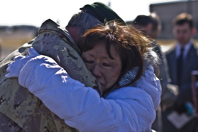 Canadian Army Brig. Gen. Peter Atkinson, III Corps Deputy Commanding General and guest speaker, embraces Jasmine Crowl, mother of Chief Warrant Officer 3 Cornell Chao, at the end of the dedication ceremony of the headquarters buildings of the 1st...