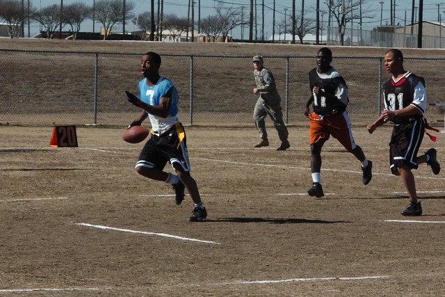 Spc. Desean Durham, with the Headquarters and Headquarters Company, Special Troops Battalion, 15th Sustainment Brigade, 13th Sustainment Command (Expeditionary), runs for a touchdown against the 418th Transportation Company, 180th Transportation...